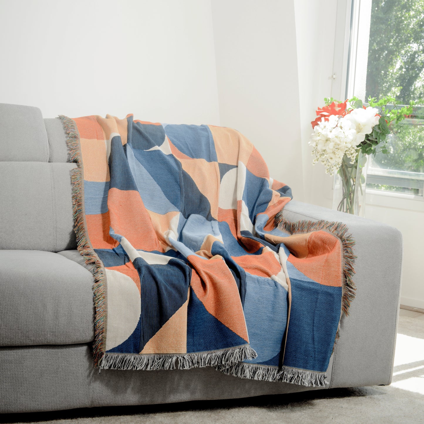 Plaid Bohème à motif posé sur un canapé dans un salon à l’ambiance cozy