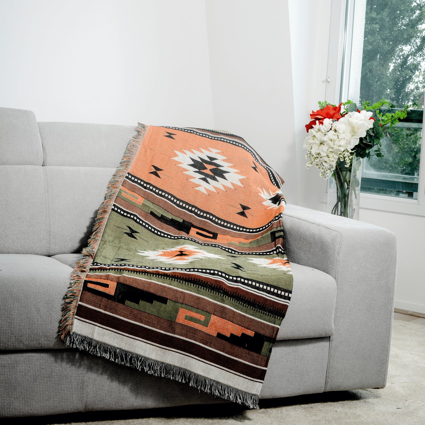 Plaid Bohème à motif posé sur un canapé dans un salon à l’ambiance cozy