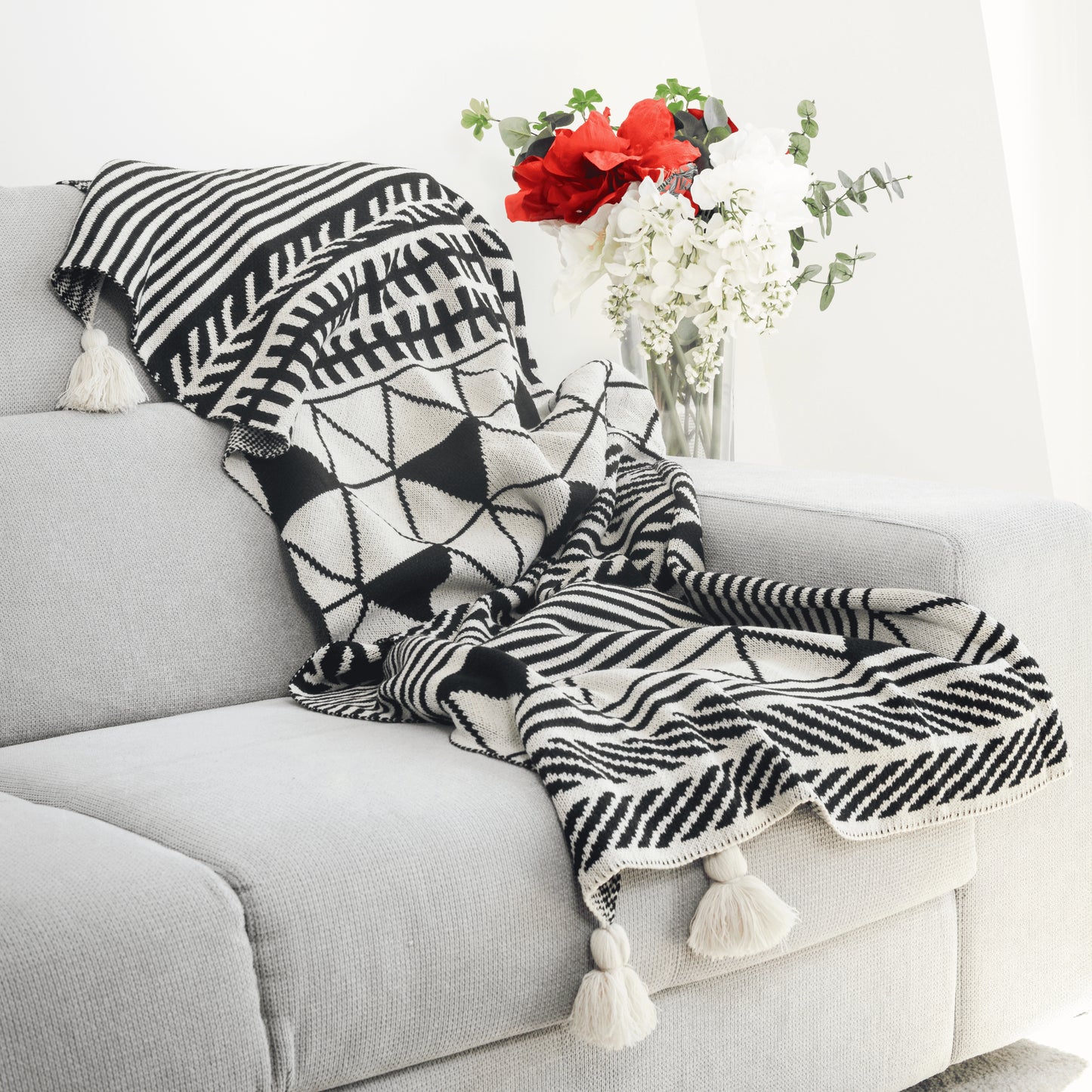 Plaid Bohème à motif posé sur un canapé dans un salon à l’ambiance cozy