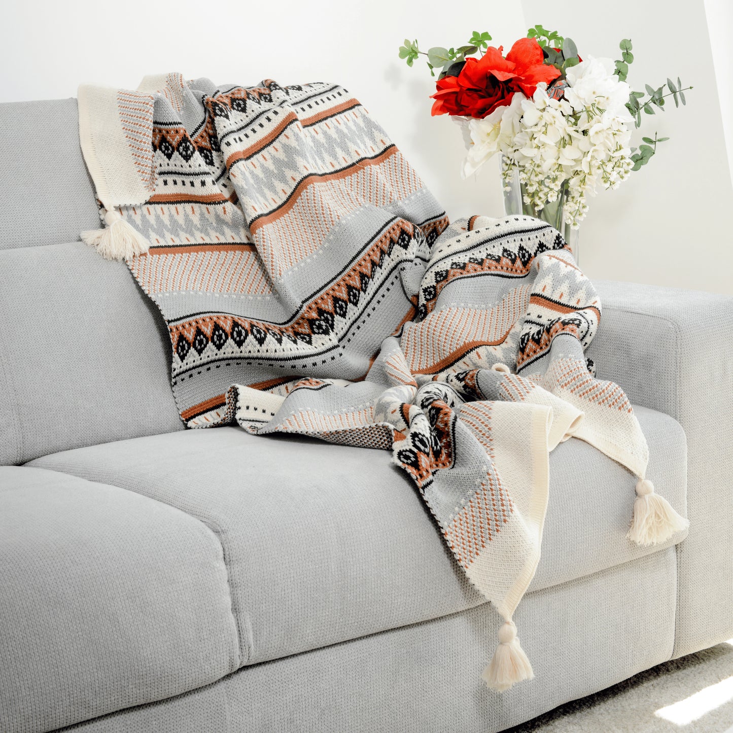 Plaid Bohème à motif posé sur un canapé dans un salon à l’ambiance cozy