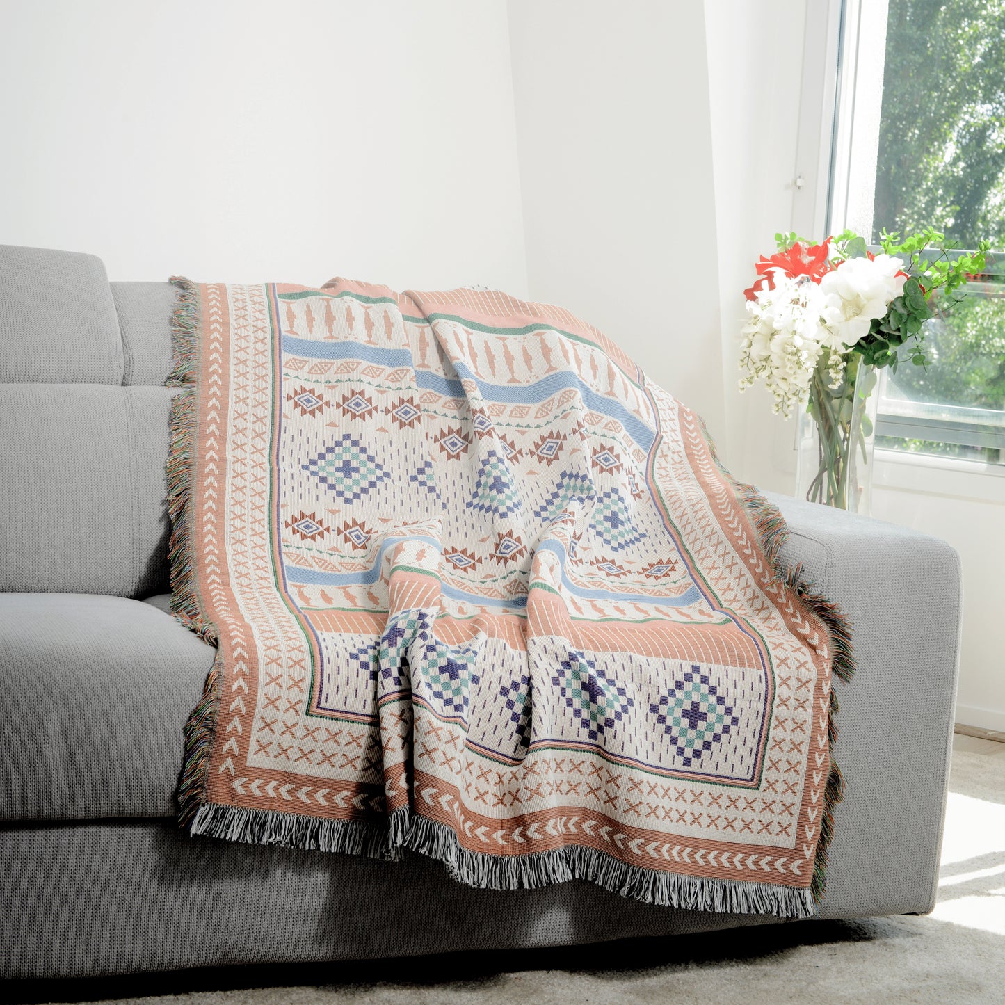 Plaid Bohème à motif posé sur un canapé dans un salon à l’ambiance cozy