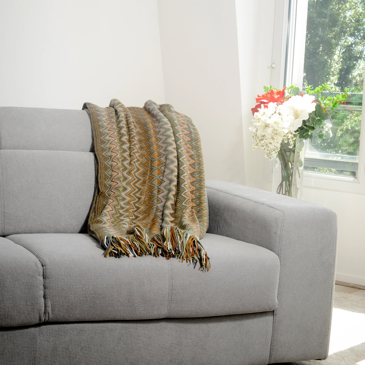Plaid Bohème à motif posé sur un canapé dans un salon à l’ambiance cozy