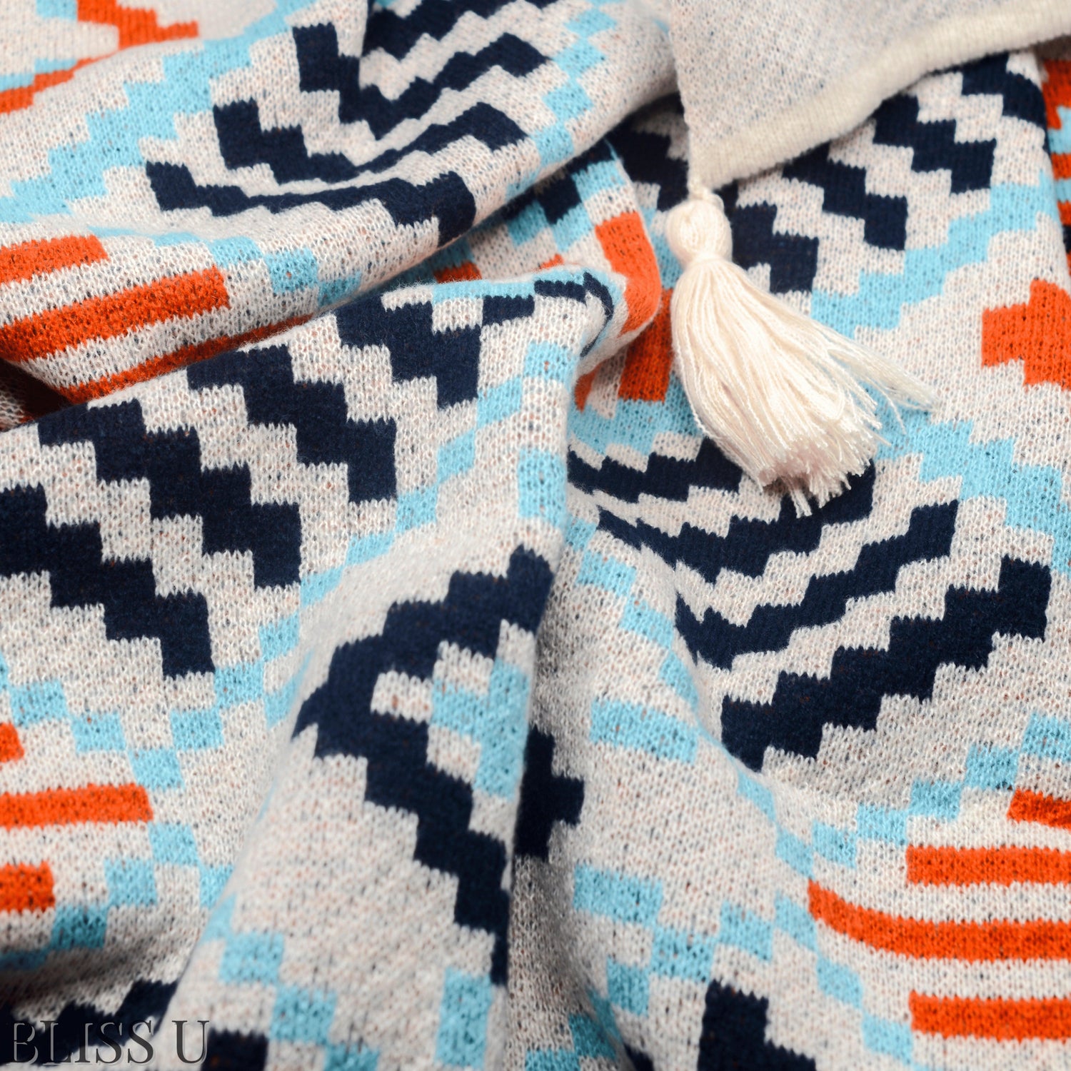 Couverture Plaid aux motifs Bohèmes froissés et vu de près avec le logo Bliss U