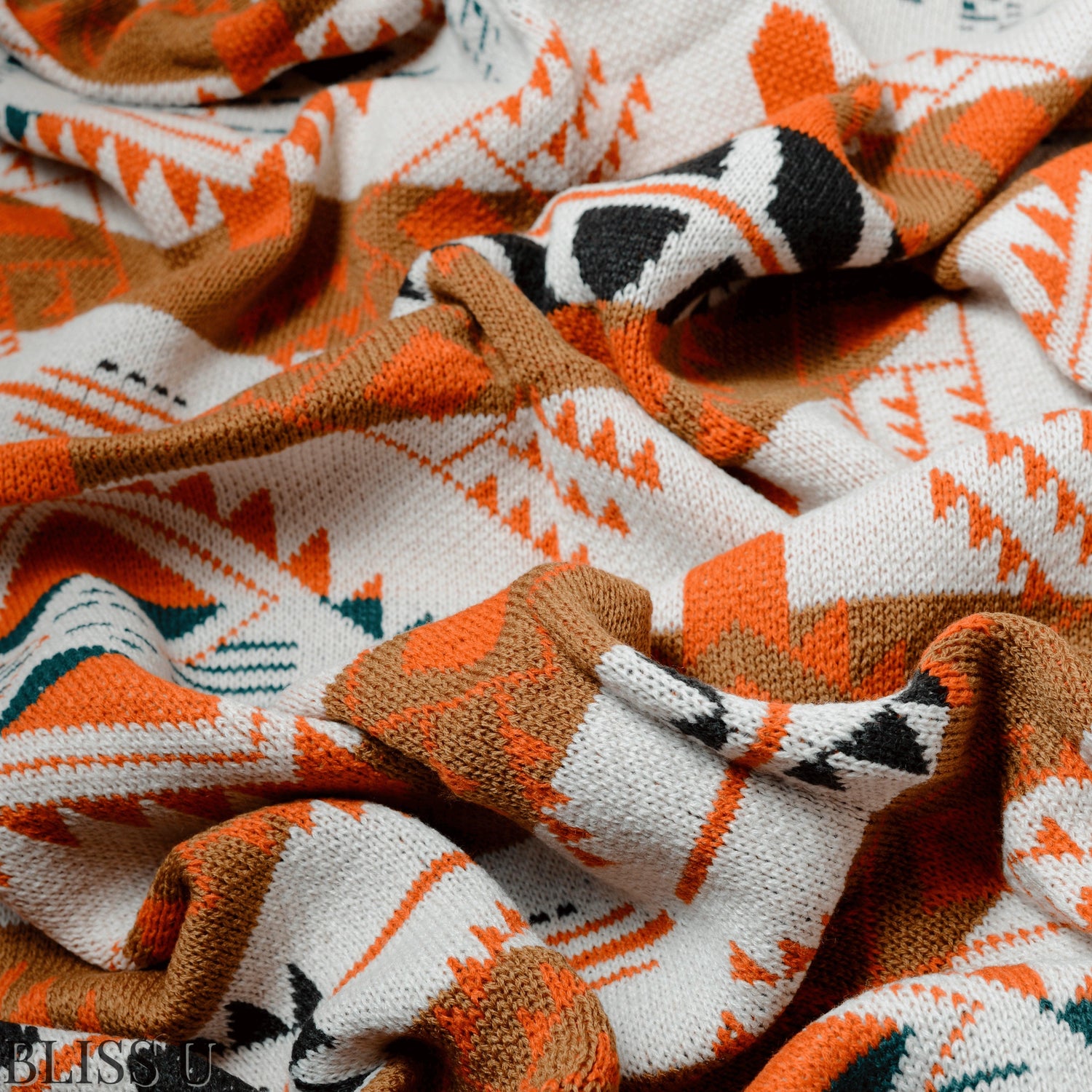 Couverture Plaid aux motifs Bohèmes froissés et vu de près avec le logo Bliss U