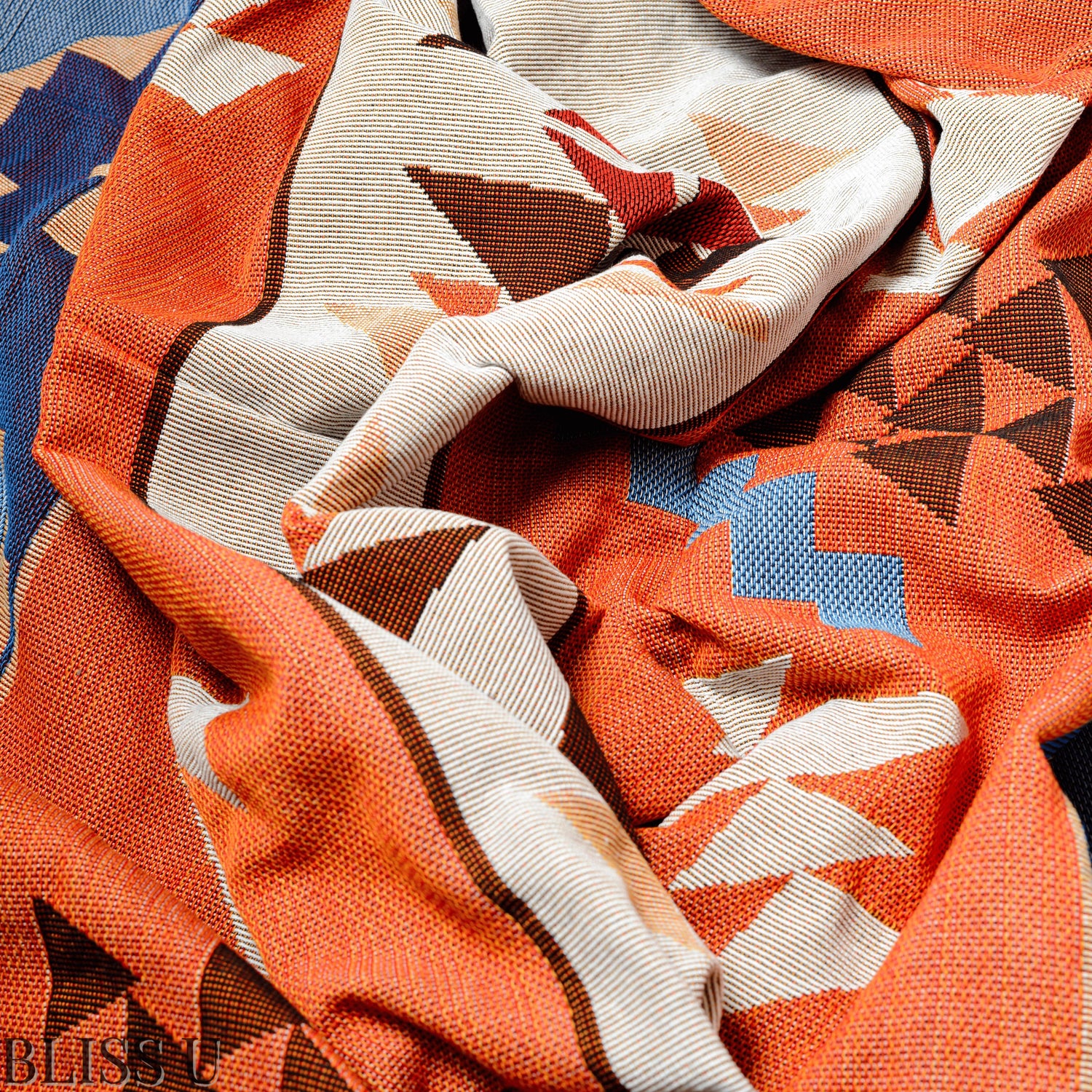 Couverture Plaid aux motifs Bohèmes froissés et vu de près avec le logo Bliss U