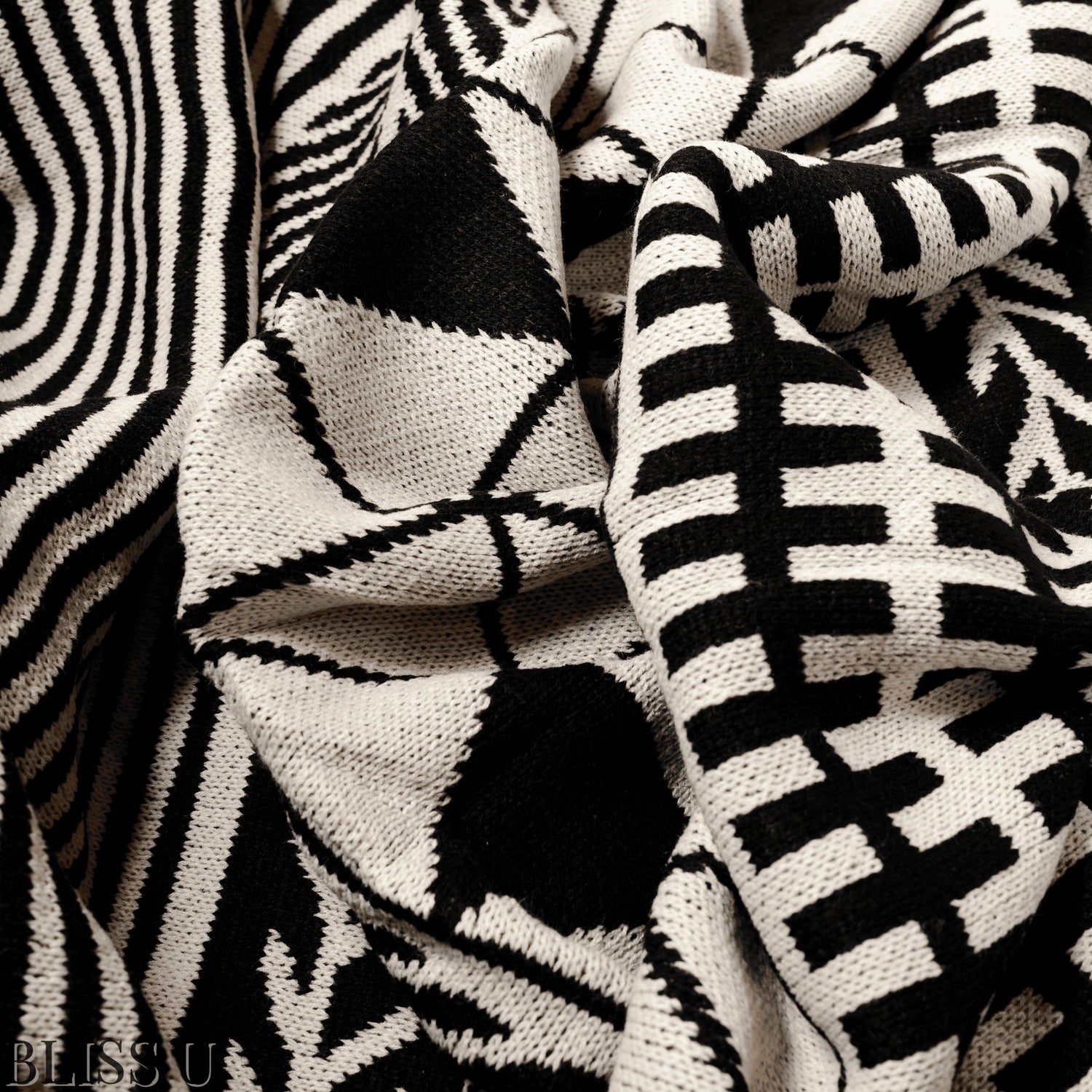 Couverture Plaid aux motifs Bohèmes froissés et vu de près avec le logo Bliss U