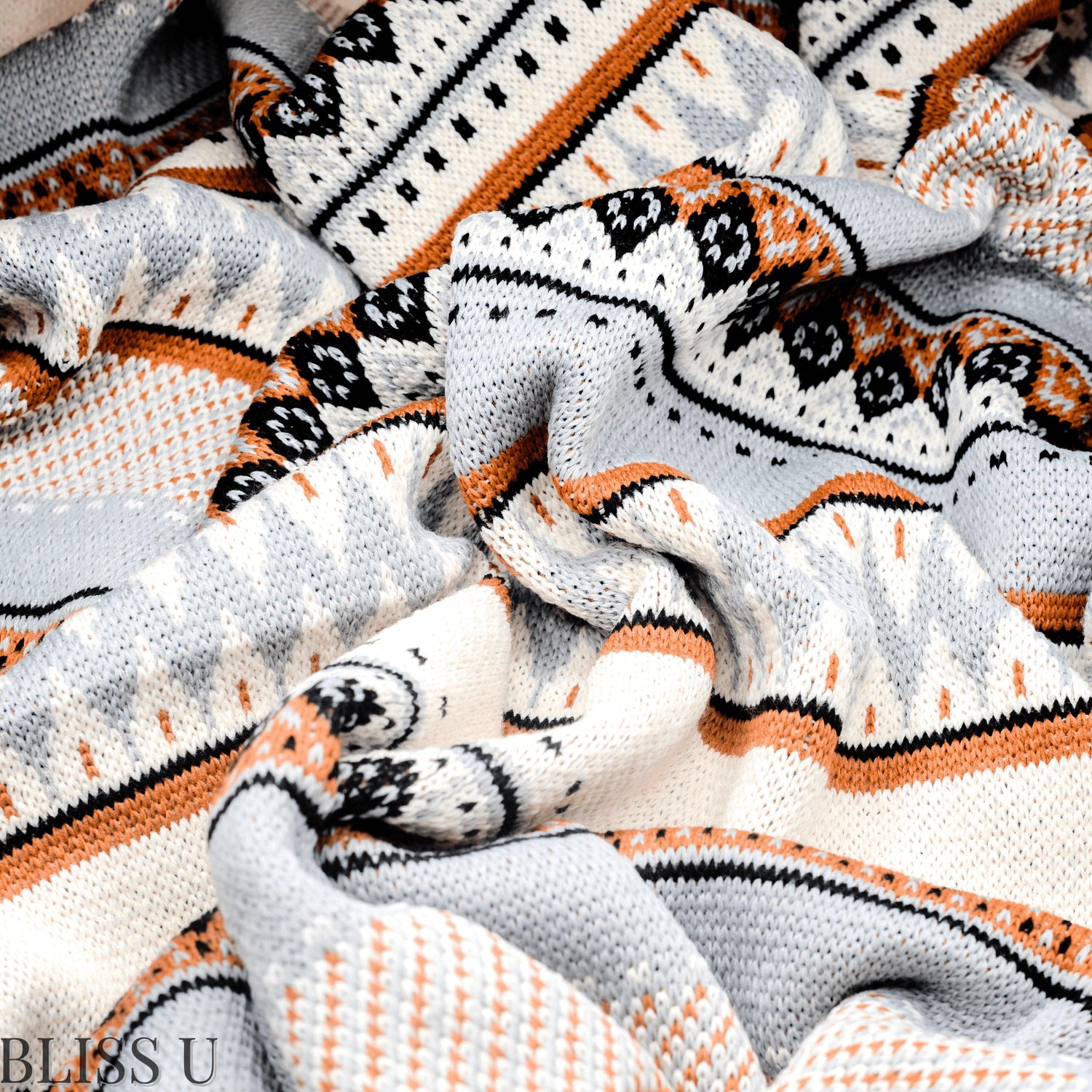 Couverture Plaid aux motifs Bohèmes froissés et vu de près avec le logo Bliss U