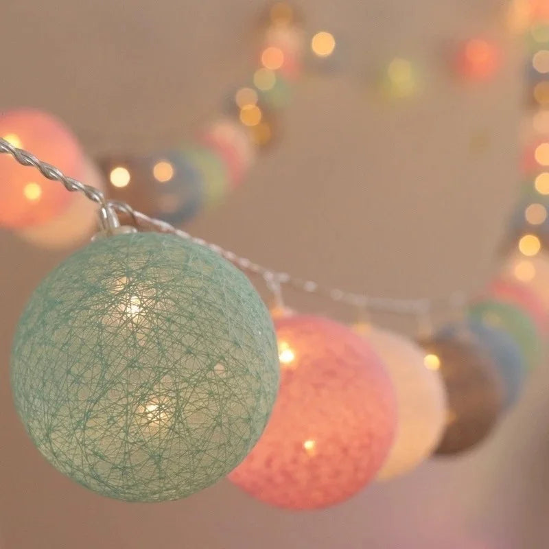 Guirlande Lumineuse en forme de Boule de coton allumé et posé sur une table dans une ambiance cosy et cocooning