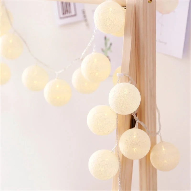 Guirlande Lumineuse en forme de Boule de coton allumé et posé sur une table dans une ambiance cosy et cocooning