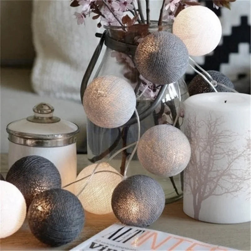 Guirlande Lumineuse en forme de Boule de coton allumé et posé sur une table dans une ambiance cosy et cocooning