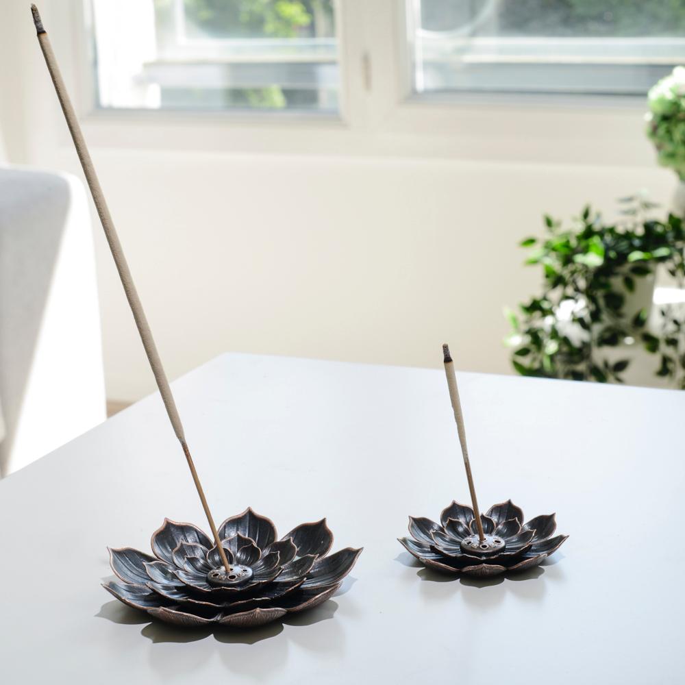 Deux Porte encens bohème en forme de lotus posé sur une table dans un salon à l’ambiance cocooning