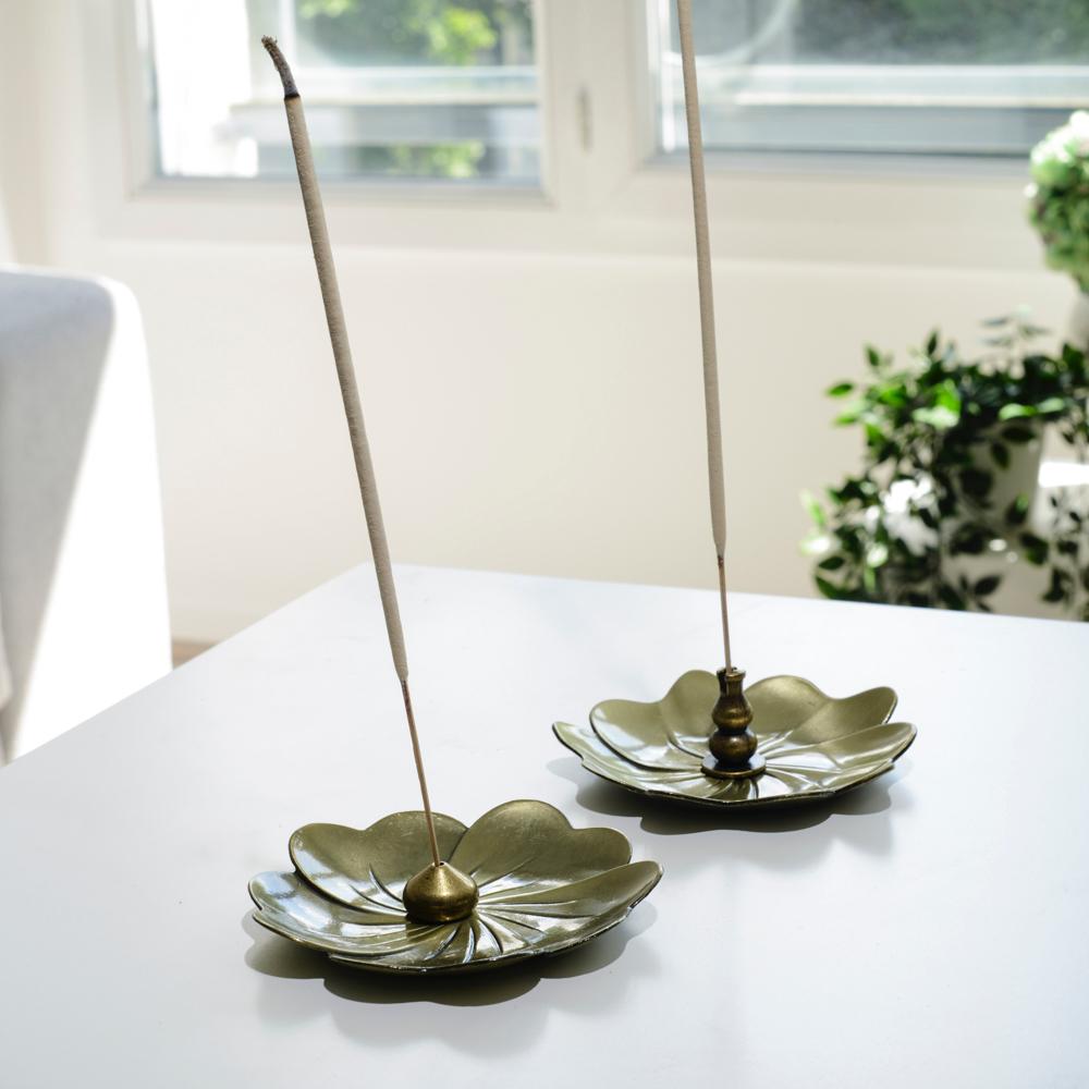 Porte encens bohème en forme de lotus posé sur une table dans un salon à l’ambiance cocooning