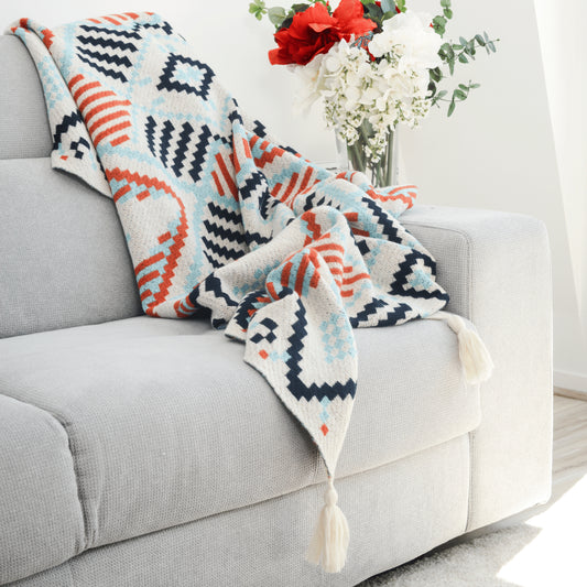 Plaid Bohème à motif posé sur un canapé dans un salon à l’ambiance cozy