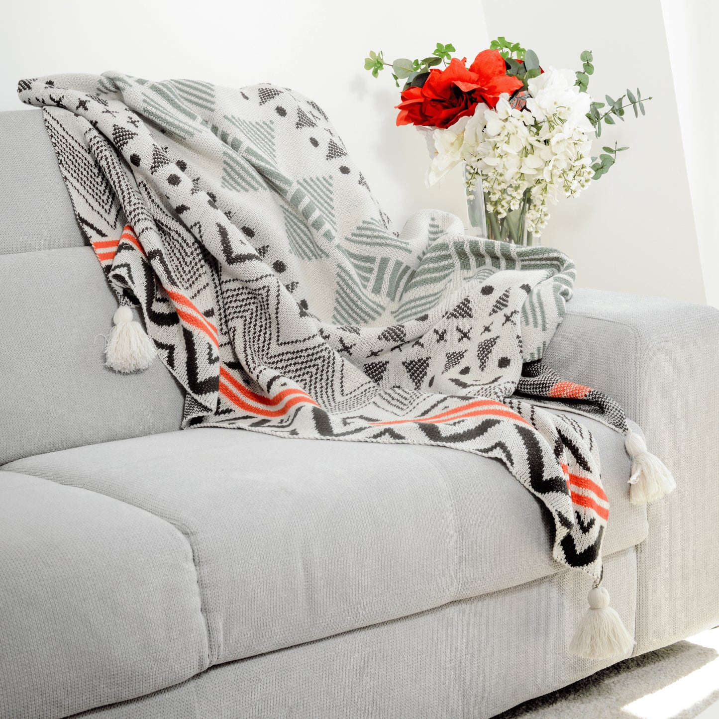 Plaid Bohème à motif posé sur un canapé dans un salon à l’ambiance cozy