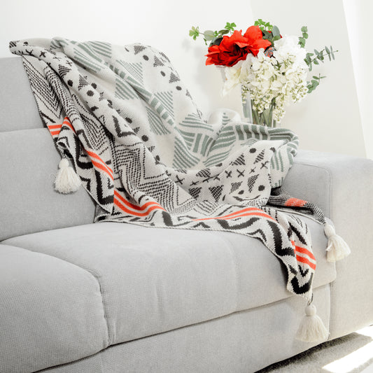 Plaid Bohème à motif posé sur un canapé dans un salon à l’ambiance cozy