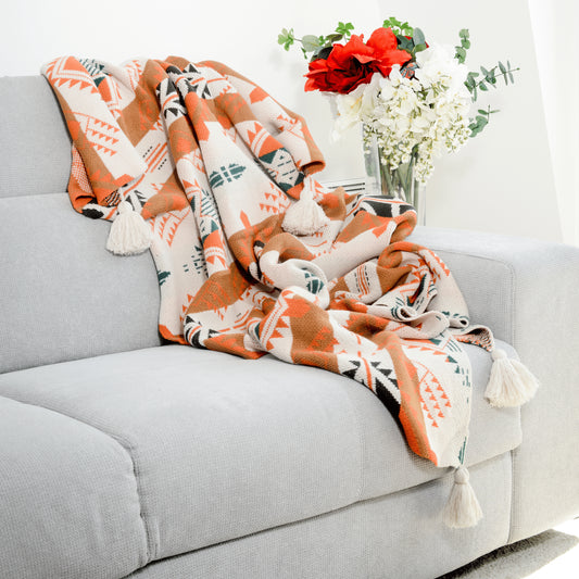 Plaid Bohème à motif posé sur un canapé dans un salon à l’ambiance cozy