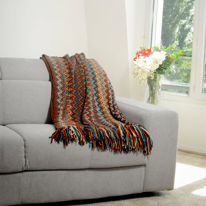 Plaid Bohème à motif posé sur un canapé dans un salon à l’ambiance cozy