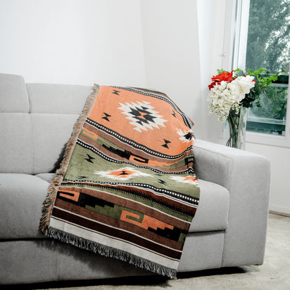 Plaid Bohème à motif posé sur un canapé dans un salon à l’ambiance cozy