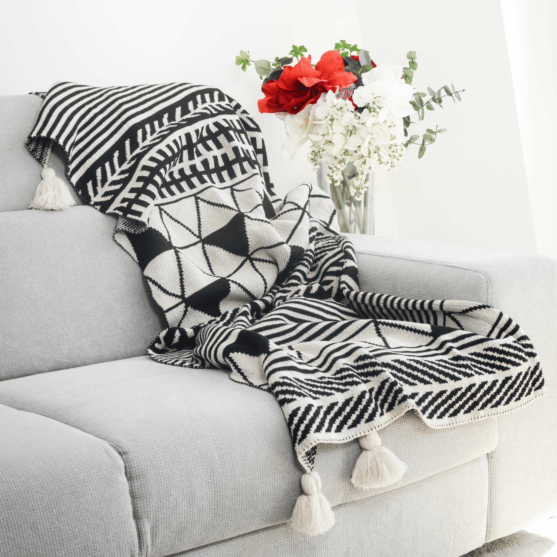 Plaid Bohème à motif posé sur un canapé dans un salon à l’ambiance cozy