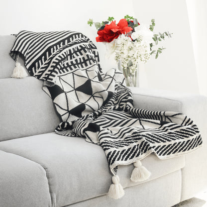 Plaid Bohème à motif posé sur un canapé dans un salon à l’ambiance cozy
