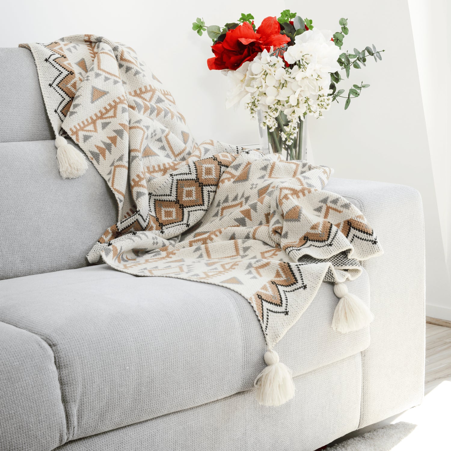 Plaid Bohème à motif posé sur un canapé dans un salon à l’ambiance cozy