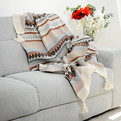 Plaid Bohème à motif posé sur un canapé dans un salon à l’ambiance cozy