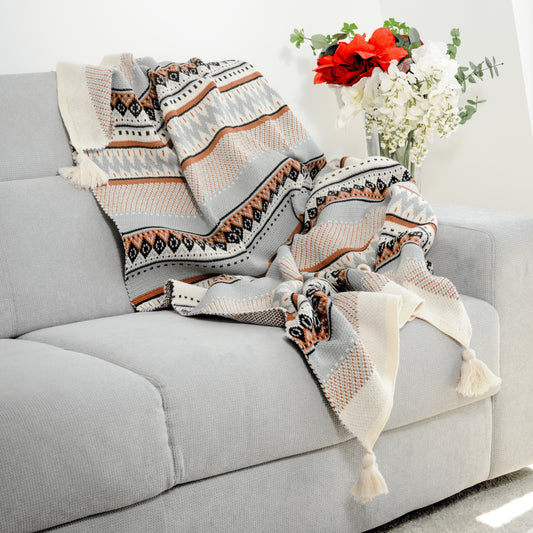 Plaid Bohème à motif posé sur un canapé dans un salon à l’ambiance cozy