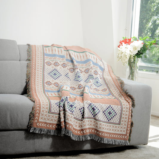 Plaid Bohème à motif posé sur un canapé dans un salon à l’ambiance cozy