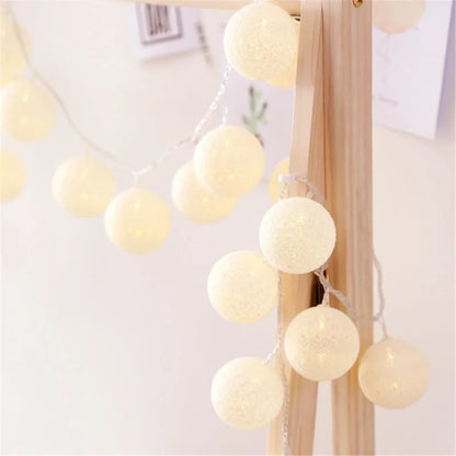 Guirlande Lumineuse en forme de Boule de coton allumé et posé sur une table dans une ambiance cosy et cocooning