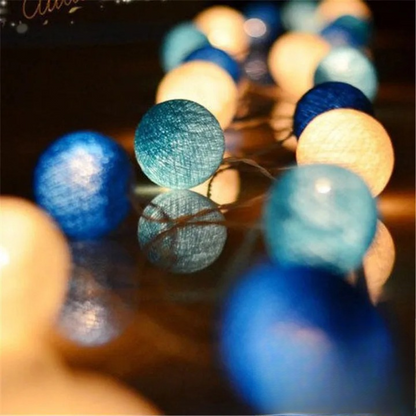 Guirlande Lumineuse en forme de Boule de coton allumé et posé sur une table dans une ambiance cosy et cocooning
