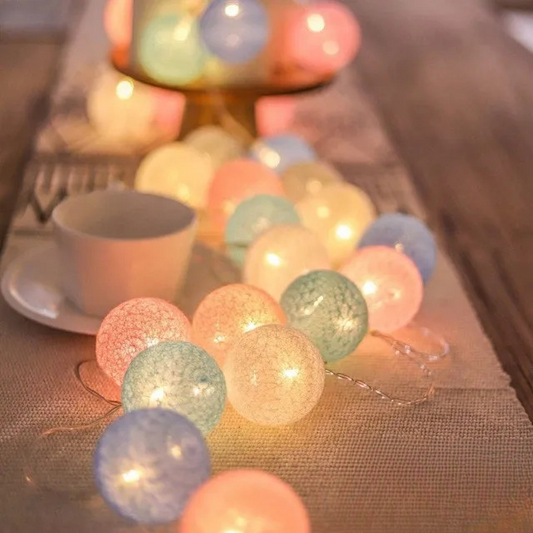 Guirlande Lumineuse en forme de Boule de coton allumé et posé sur une table dans une ambiance cosy et cocooning