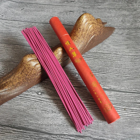 Boite d’encens avec ses encens posé sur une table et appuyé contre une branche dans une ambiance boheme
