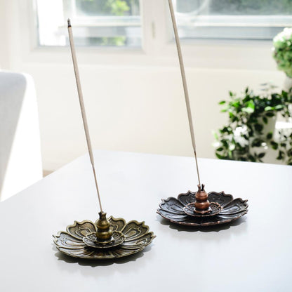 Porte encens bohème en forme de lotus  de bronze posé sur une table dans un salon à l’ambiance cocooning